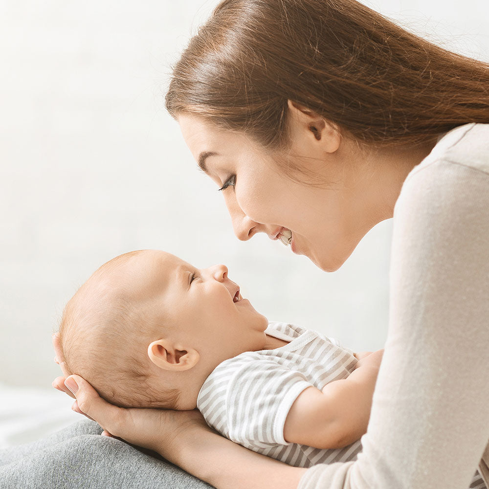 Mom holding baby smiling